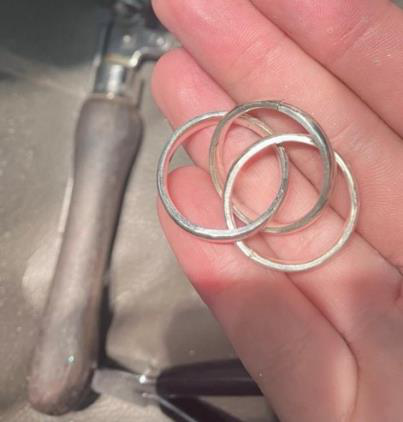 Three interlocking sterling silver rings forming a Russian wedding band